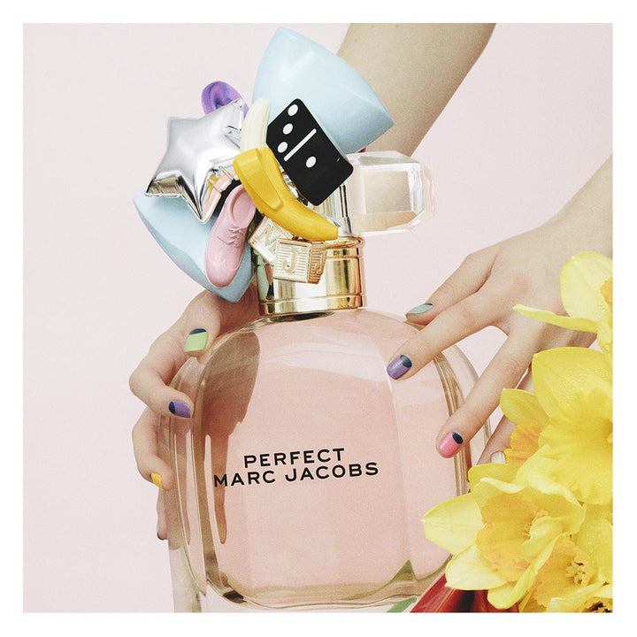 Rounded glass bottle with pink perfume and decorative charms, 50 ml