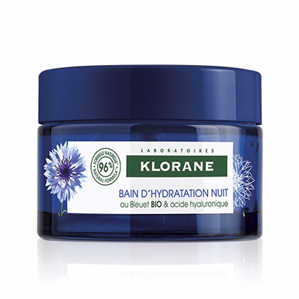 Jar of Klorane night cream with cornflower motif, creamy texture on applicator