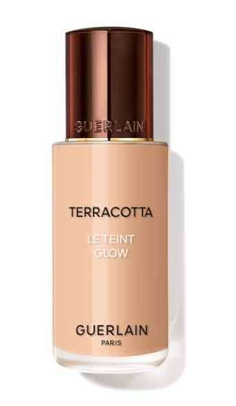 Glass bottle foundation with pump, warm beige liquid, luminous finish, refined minimalist packaging, Guerlain