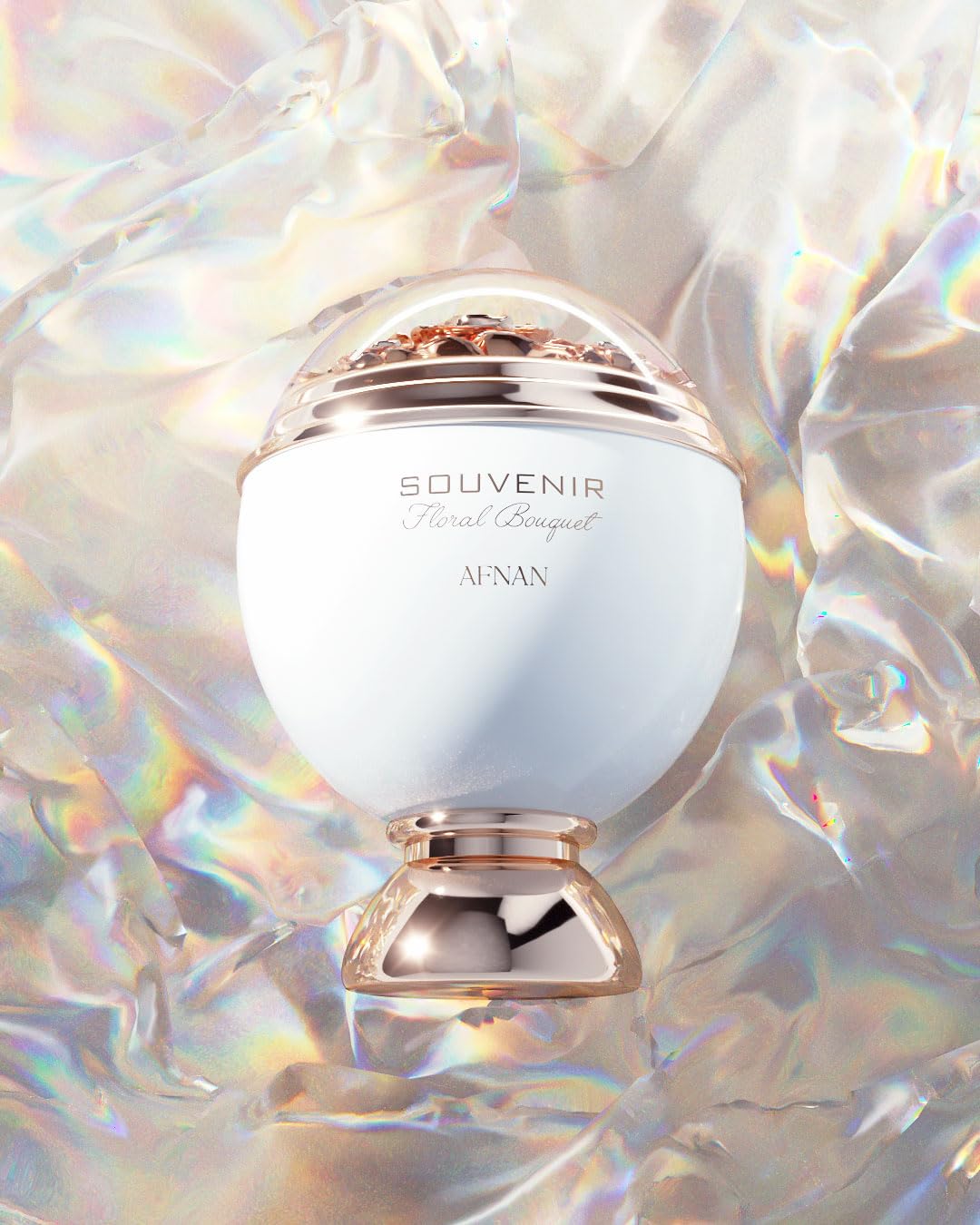 White dome perfume bottle with gold decorative base and floral detail under transparent top, Afnan.