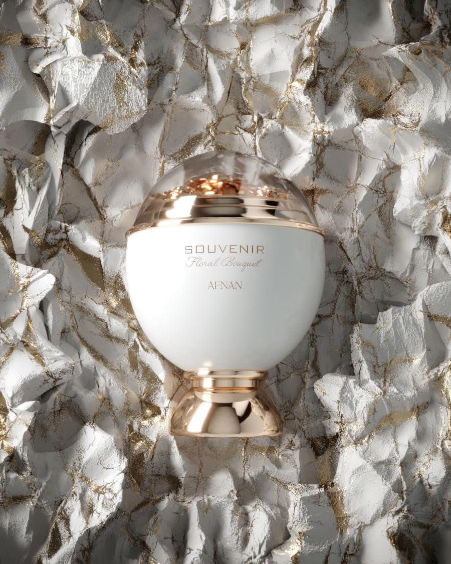 White dome perfume bottle with gold decorative base and floral detail under transparent top, Afnan.