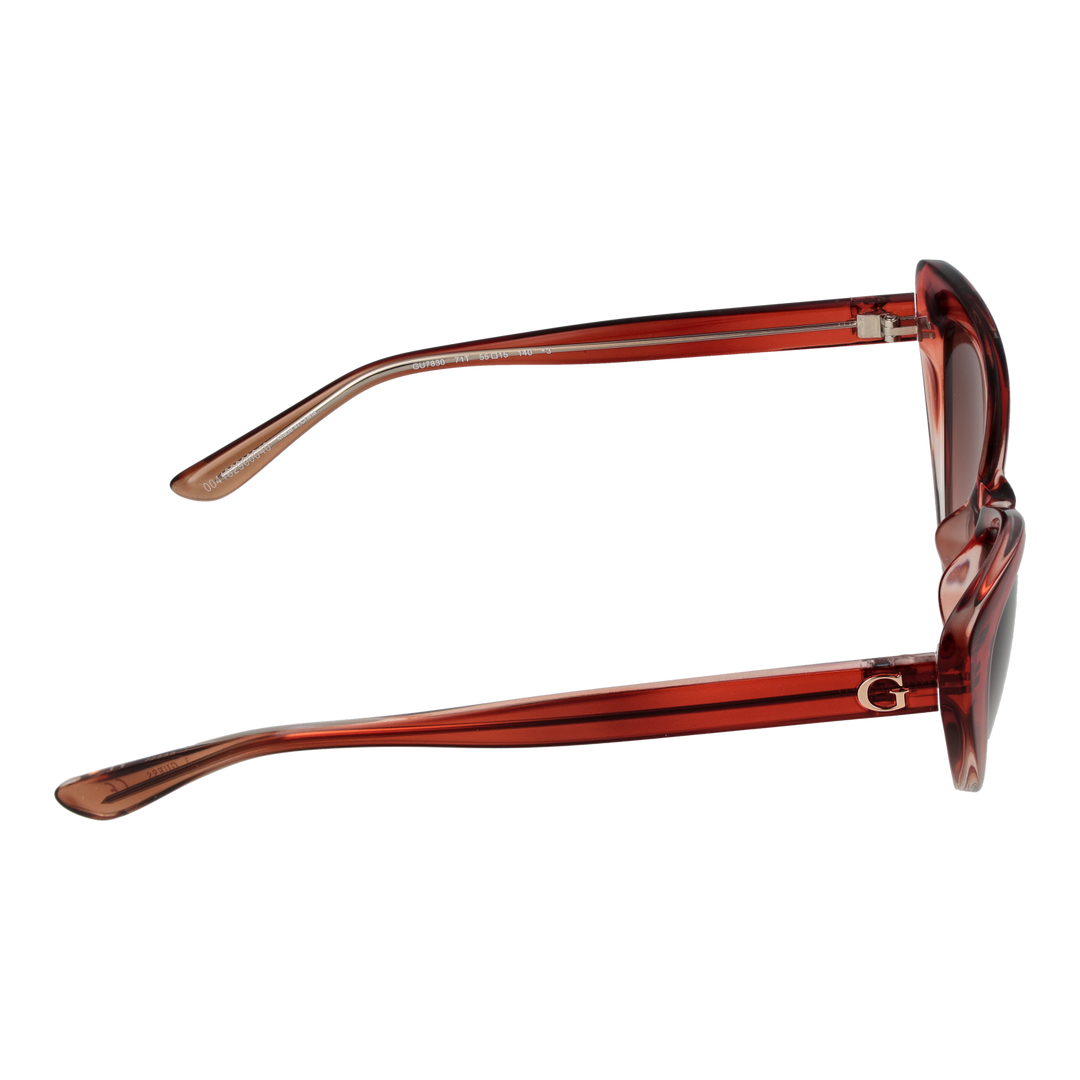 Transparent red cat-eye sunglasses in plastic with gradient lenses shown at three-quarter angle