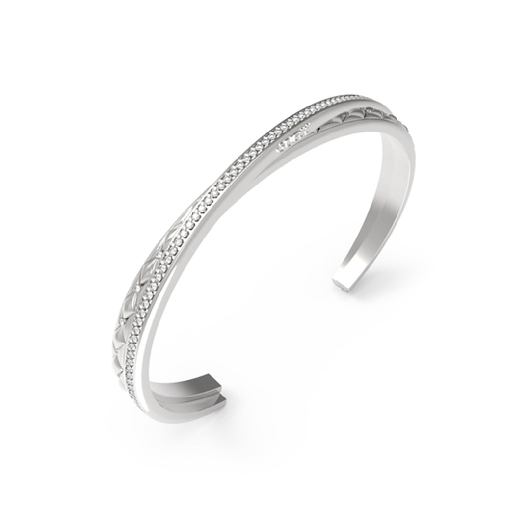 Silver textured bracelet with a row of small crystals on a neutral background, elegant close-up